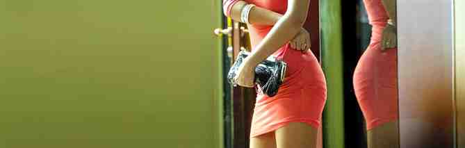 A young woman feeling her burning bottom in a tight dress after getting spanked